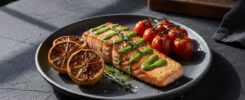 AI-generated gourmet seared salmon fillet with green herb sauce drizzle, grilled lemon, roasted cherry tomatoes on vine, thyme garnish – free download for SEO and web use